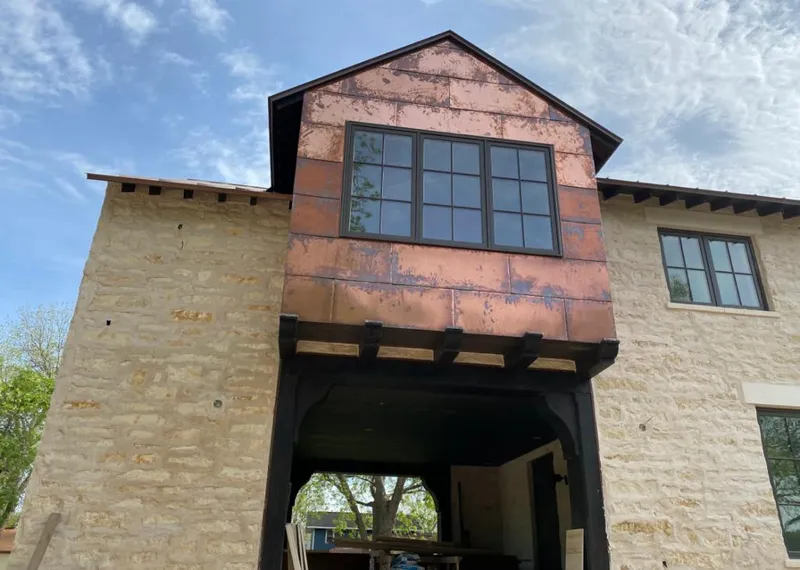 Copper metal panel facade on a stone building for Skylight Installation in Westgate